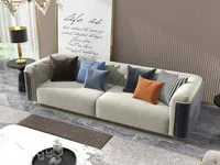 Close view of beige sofa with colorful pillows, marble coffee table with tray, and lamp