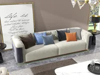 Close up of beige sofa with colorful pillows wall art black table lamp and floor