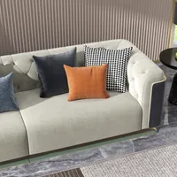 Elegant light grey fabric sofa with orange and checkered pillows against a striped wall panel
