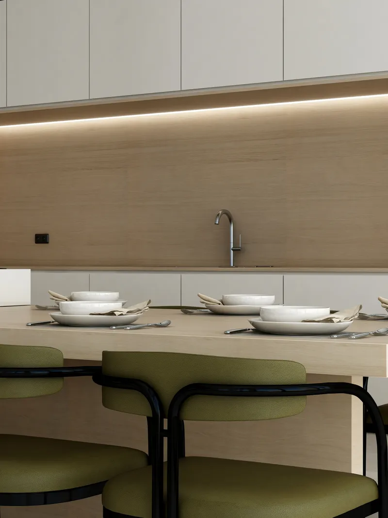 Minimalist dining table with white plates and green chairs set against a wooden kitchen sink