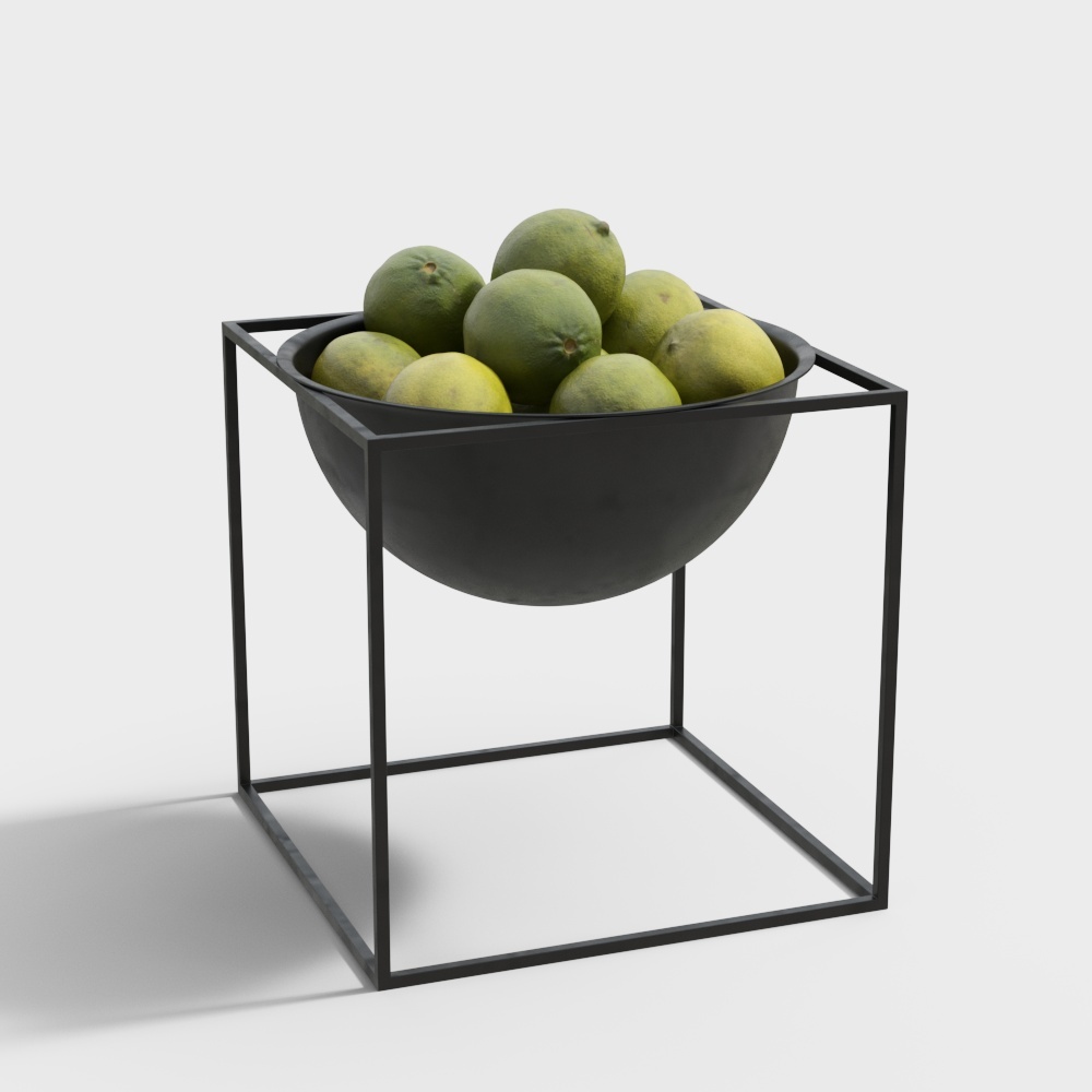 Modern black metal fruit bowl with geometric frame and green citrus fruits on white background