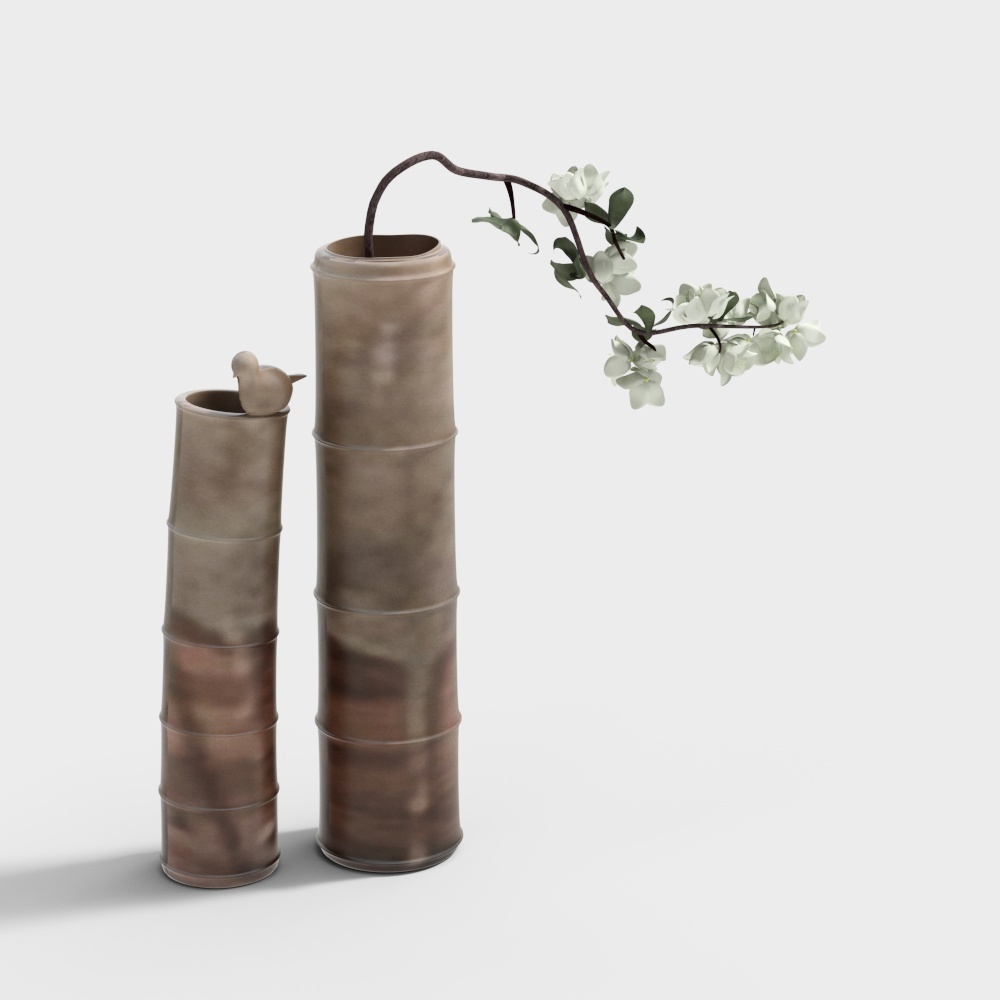 Two tall bamboo style vases with bird and white flowers on grey background