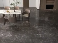 Dining area featuring dark marble floor, stone table, four beige chairs, and wooden wall panels