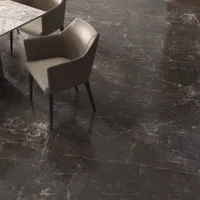High angle view of a modern brown chair and marble table on dark marble flooring