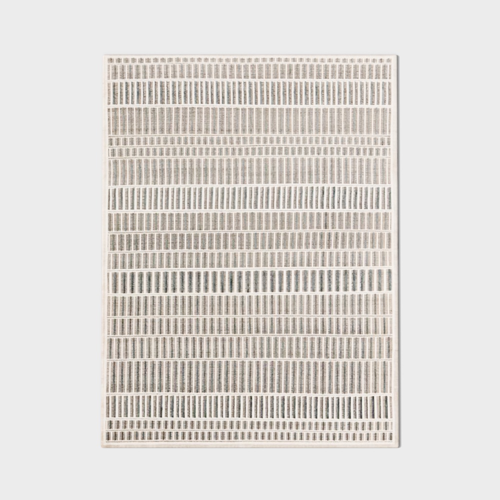 Modern geometric patterned rug with grey and white stripes on light grey background