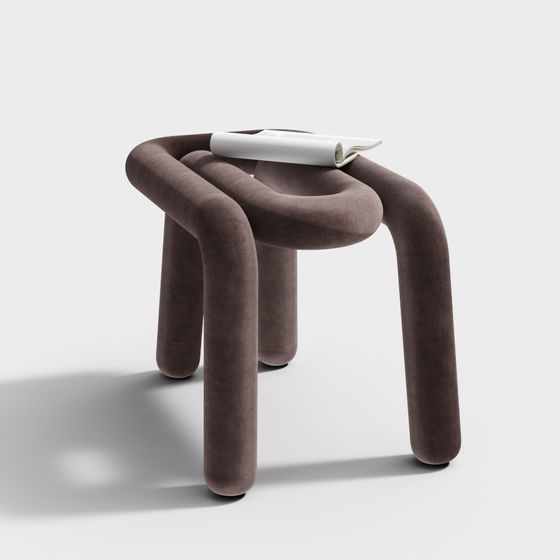 Modern brown velvet stool with curved legs and magazine on white background