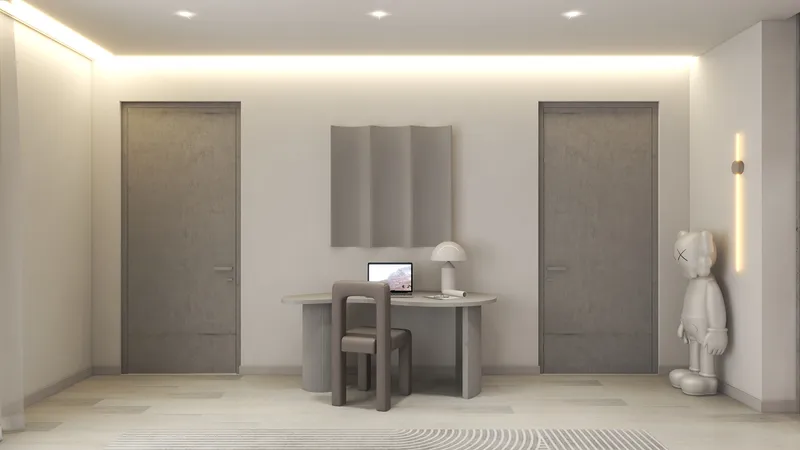 Modern home office featuring grey doors, curved desk, laptop, white table lamp, and character statue